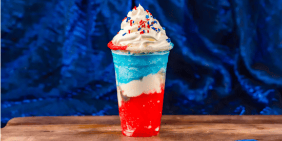A red, white, and blue slushy in a clear cup. 