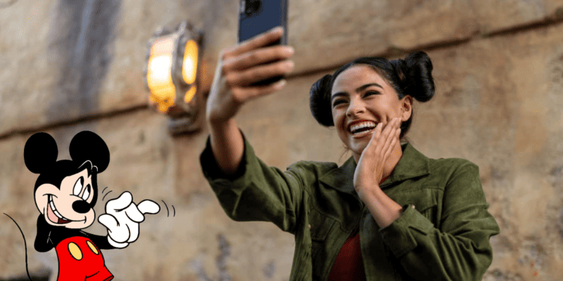 Influencer taking pictures at Disney Park (Selfie at Star Wars: Galaxy's Edge) with Mickey Mouse waving nervously