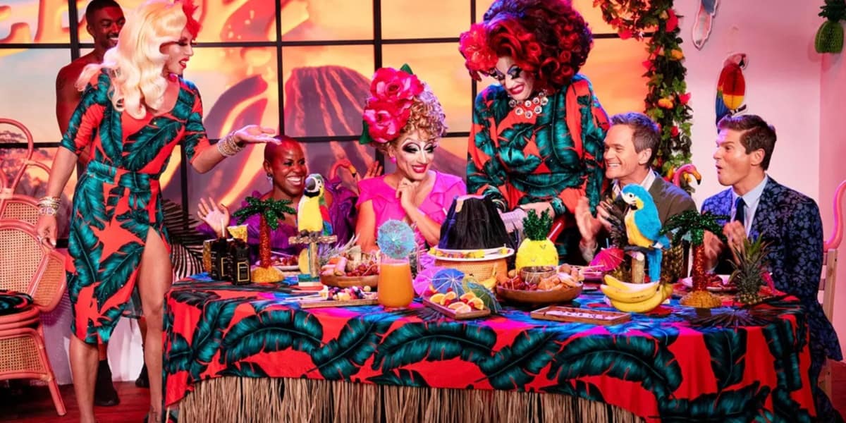 Judges and contestants enjoying a tropical dinner party on Drag Me to Dinner on Disney Plus