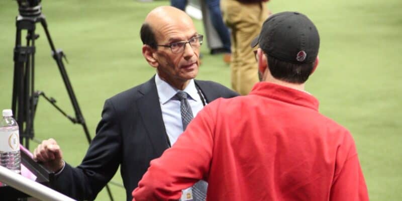 ESPN personality Paul Finebaum having a serious conversation on the field