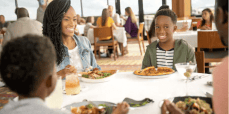 A family eating around a dinner table at a Walt Disney World hotel.
