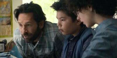 Paul Rudd, Logan Kim, and McKenna Grace looking at old footage in 'Ghostbusters: Afterlife'
