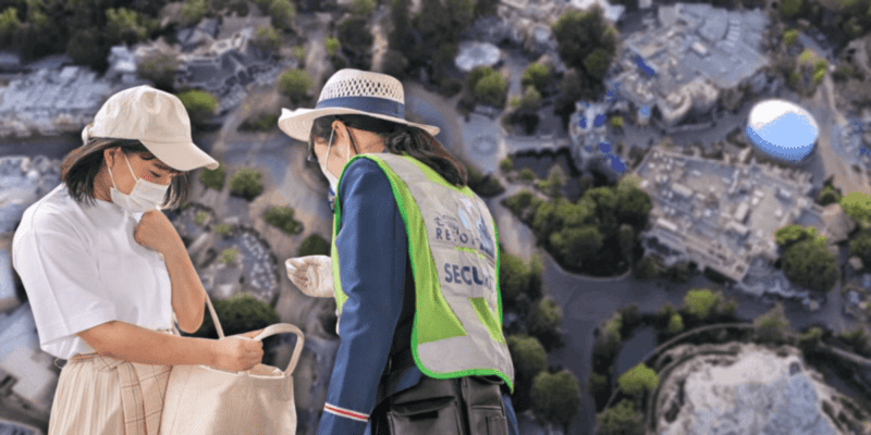 A Disneyland security Cast Member checks a Guest's bag in front of an aerial shot of Disneyland Park.