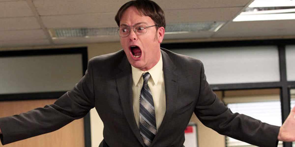 Rainn Wilson as Dwight Schrute in The Office on his desk screaming "DWIGHT SCHRUTE IS MANAGER"