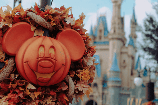 Carved Mickey Mouse pumpkin decor with fall leaf arrangement