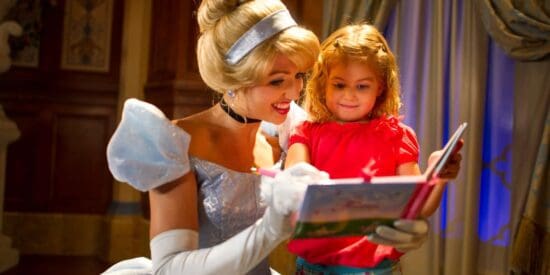 Cinderella signs an autograph for a little girl.