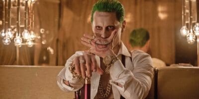 Jared Leto as Joker in 'Suicide Squad' covering his mouth with his hand that has a mouth tattoo