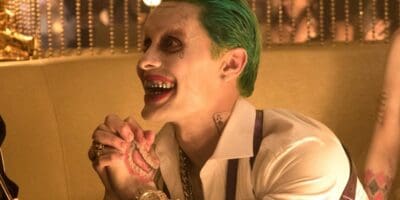 Jared Leto as the Joker in Suicid Squad holding his hands together and smiling