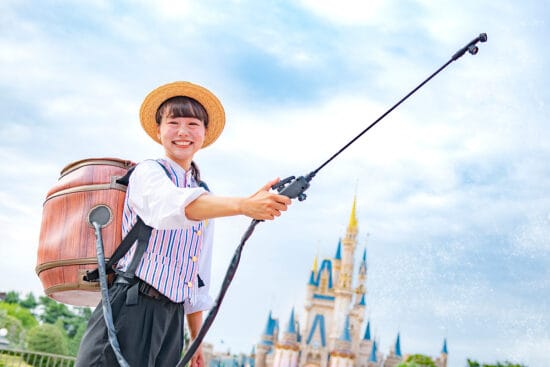 A Tokyo Disney Resort Cast Member holding a spraying gun that is used to cool down Guests during the intense summer heats in Japan