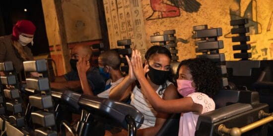 Guests ride Revenge of the Mummy: The Ride wearing masks