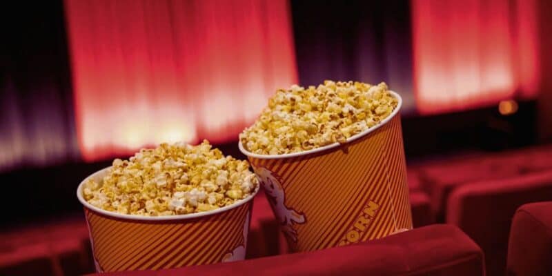 two large popcorn buckets together inside of a movie theater