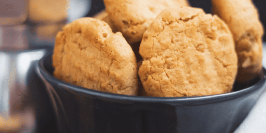 A black glass bowl filled with peanut butter cookies