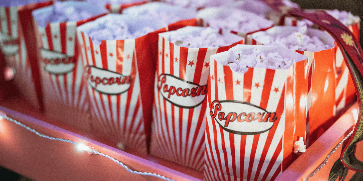 Tray filled with bags of popcorn and decorated with string lights