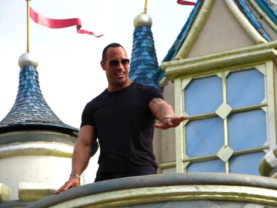 Dwayne Johnson pictured standing atop a castle at Disney World Hong Kong and greeting the crowd below.