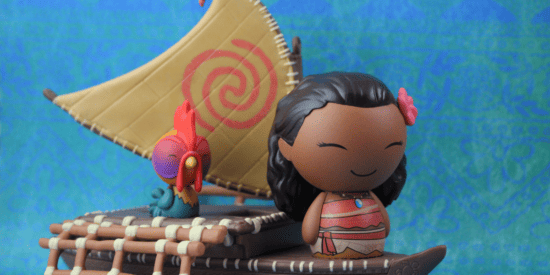 Small Moana toy figure resting on toy raft with Heihei the bird