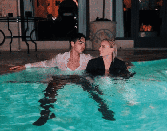 Joe Jonas pictured with soon-to-be ex-wife Sophie Turner fully clothed and embracing one another in a swimming pool