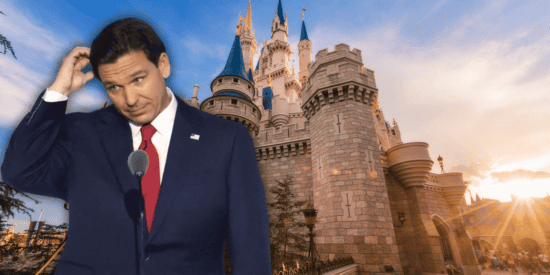Ron DeSantis holds his hand over his head in front of Cinderella Castle at Walt Disney World.