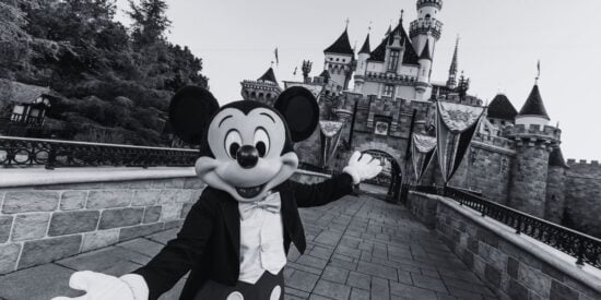 Mickey Mouse in front of the Disneyland Resort castle in California in black and white