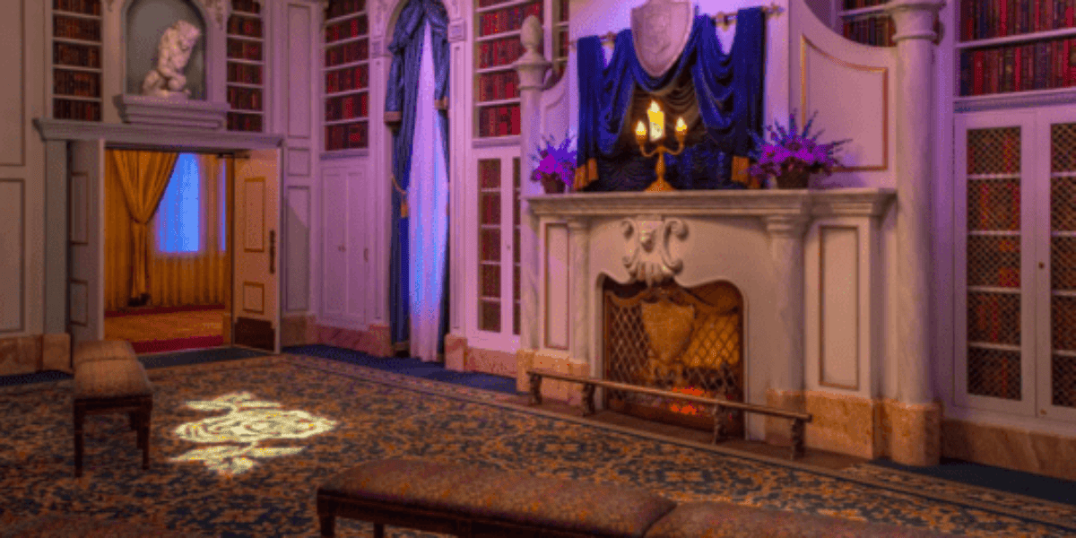 An empty library-style room featuring a Lumiere animatronic at Enchanted Tales With Belle.