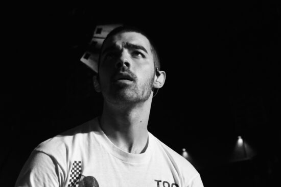 Joe Jonas pictured performing in black and white with an earpiece in his left ear