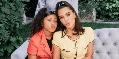 North West and Kim Kardashian sitting side by side while making 'duck faces' and posing for the camera