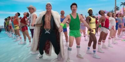 All of the Kens from Barbie holding hands on the beach