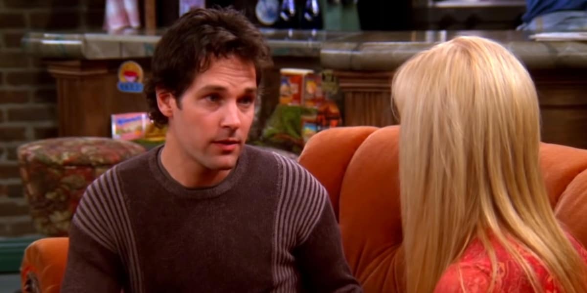 Paul Rudd speaking to Lisa Kudrow on an orange couch at Central Perk on Friends