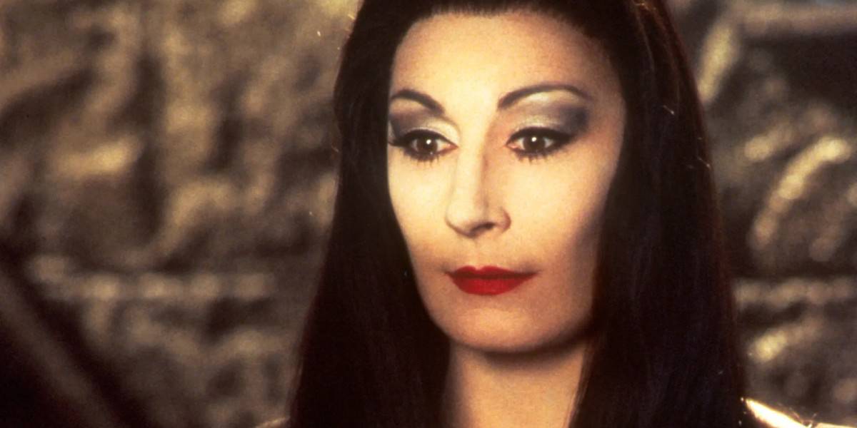Morticia Addams (Anjelica Huston) smiling while light shines only on her eyes