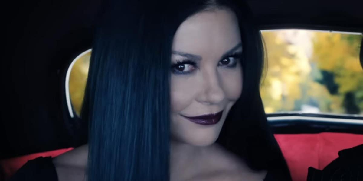 Morticia Addams (Catherine Zeta-Jones) smiling oddly in a car