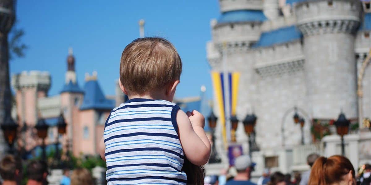 boy on parents shoulders at Magic Kingdom