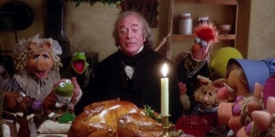 Ebenezer Scrooge eating Christmas dinner with a bunch of Muppets