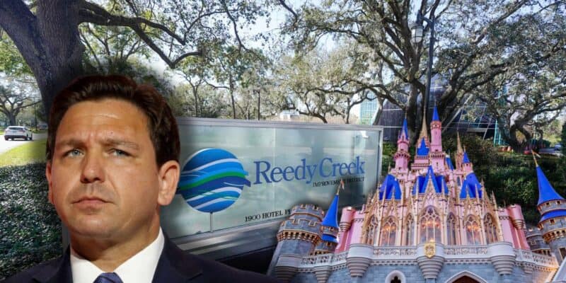 Governor Ron DeSantis frowning with the Reedy Creek signage in the background with the Cinderella Castle to the right.