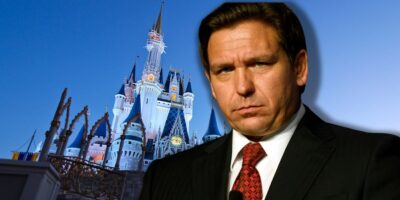 Florida Governor Ron DeSantis looking sad in front of the Cinderella Castle at Disney World.