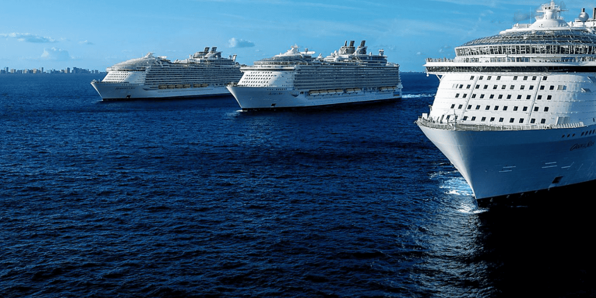 Three Royal Caribbean ships sailing in the ocean, including Allure of the Seas.