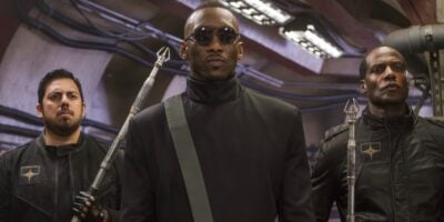 Mahershala Ali walking down a hallway with two guards
