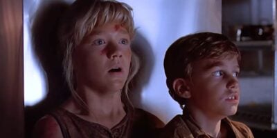 (L to R) Lex (Ariana Richards) and Tim (Joe Mazzello) hiding in the kitchen in 'Jurassic Park'
