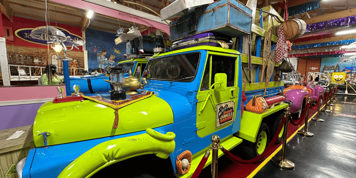 A Minnie's Jammin' Jungle Parade truck, which is bright green and bright blue, on display.