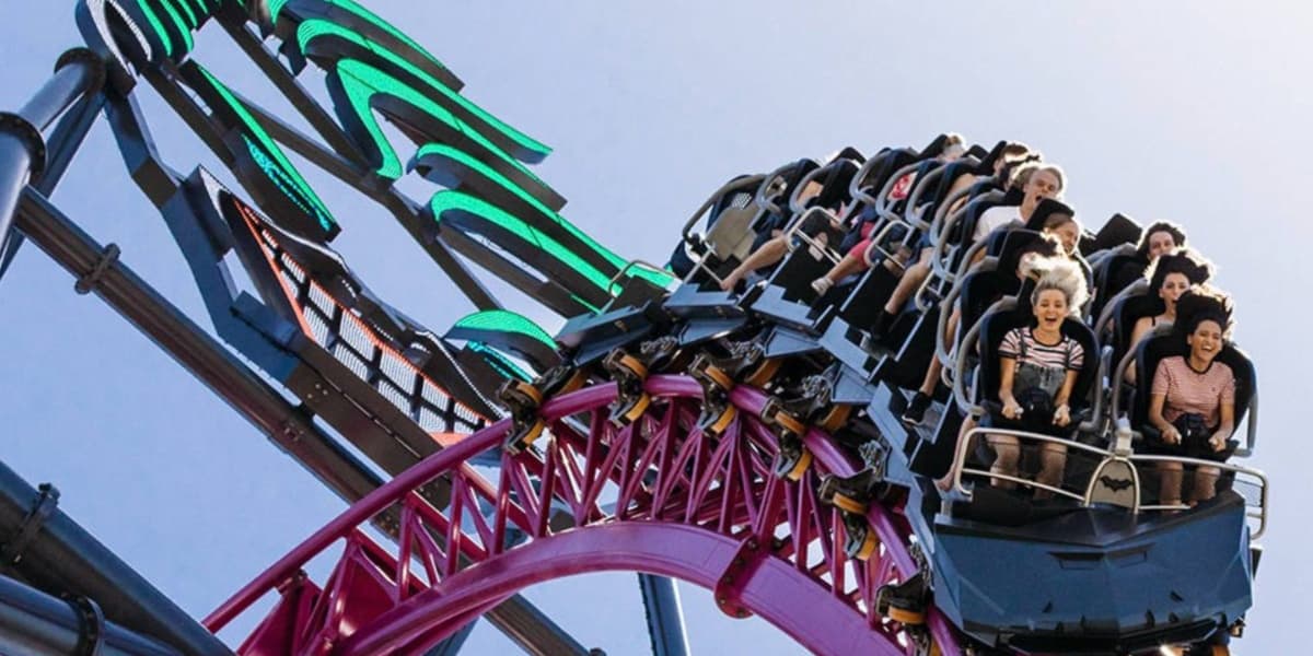 Riders going over the hill with the Joker in the background on DC Rivals HyperCoaster