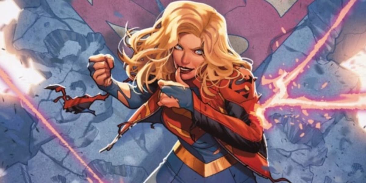 Supergirl in a torn costume, smiling, and wiping the blood off her lips