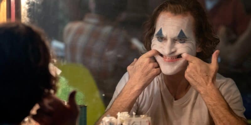 Joaquin Phoenix as Joker forcing a smile on his face