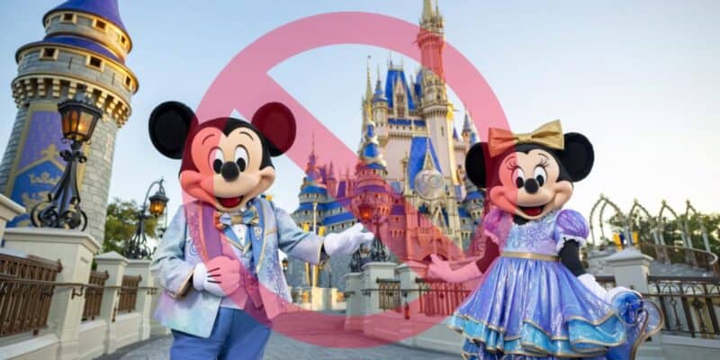 Mickey and Minnie Mouse in front of Cinderella Castle at Disney, with a large pink prohibition sign superimposed over the image, captured through My Disney Experience.