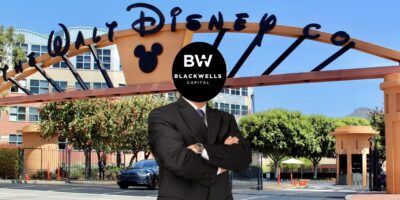 A Blackwells Capitol business man with his arms crossed standing in front of the Walt Disney Company building.