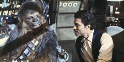 Lando Calrissian wearing Han Solo's clothes talking with Chewbacca in the cockpit of the Millennium Falcon. Still image from 'Star Wars The Empire Strikes Back'