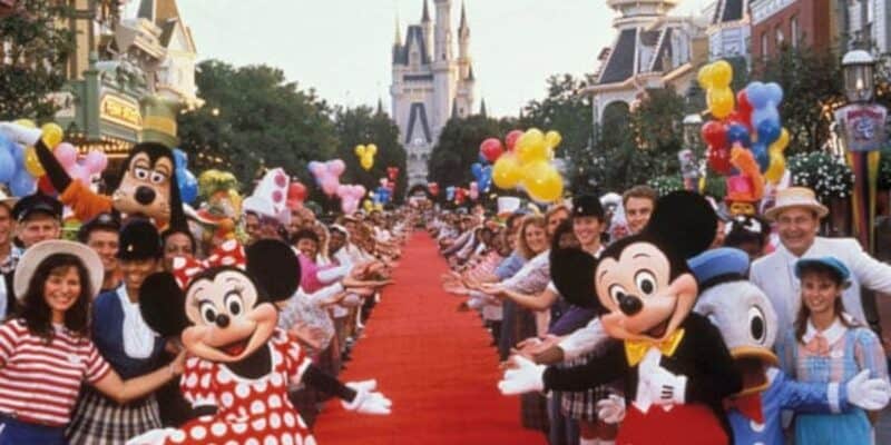 A vintage photo of Disney cast members posing with Mickey & Minnie on Main Street, U.S.A.