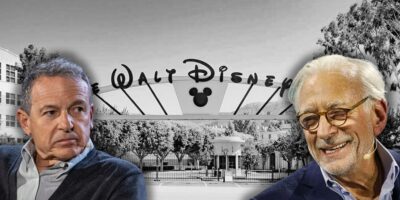 Disney CEO Bob Iger looking stressed at billionaire investor Nelson Peltz with the Walt Disney Company front gate in the background.