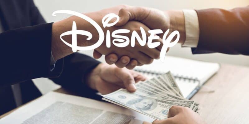 Disney logo over hands exchanging money