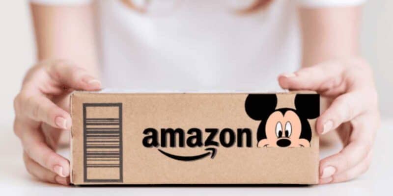 Close-up of hands presenting a small amazon parcel featuring a playful mickey mouse design on the front.