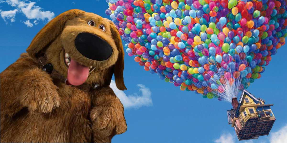 A cheerful cartoon dog smiling next to a flying house lifted by numerous colorful balloons against a bright blue sky with clouds.