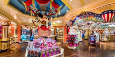 Step inside a magical and colorful Disney store, where Mickey Mouse welcomes you with open arms from his high-flying hot air balloon, surrounded by an array of Disney merchandise and festive decoration reflecting the recent price