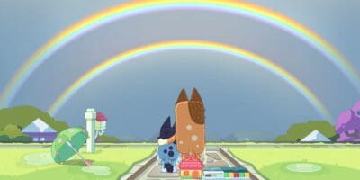 Bluey and Chilli underneath a double rainbow